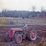 An image of Carroll Smith on on his red tractor in a field